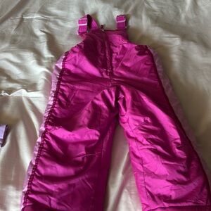 Girls, pink snow bib pants with adjustable straps.